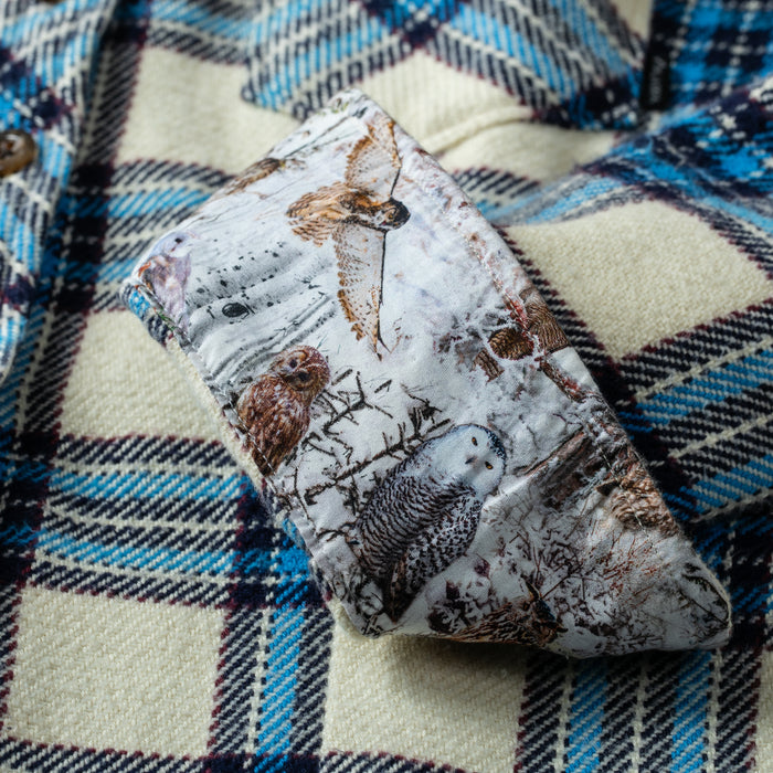 An owl-patterned cloth rests on a Pladra Women's Fireside Flannel- Tahoe Tan background.