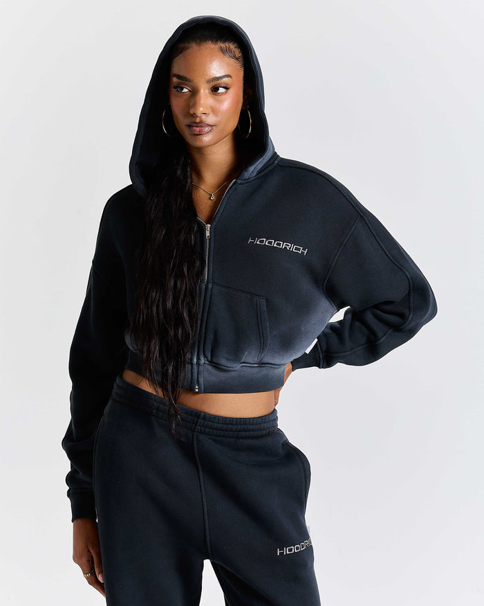 Person wearing a black hoodie and sweatpants with 'Hoodrich' branding on a white background
