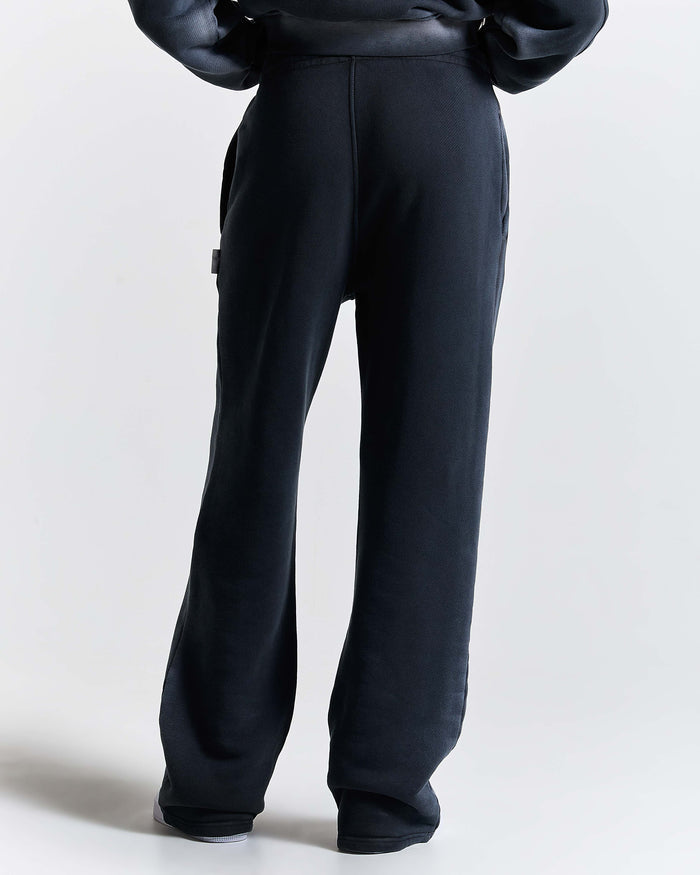 Black pants worn by a person on a white background
