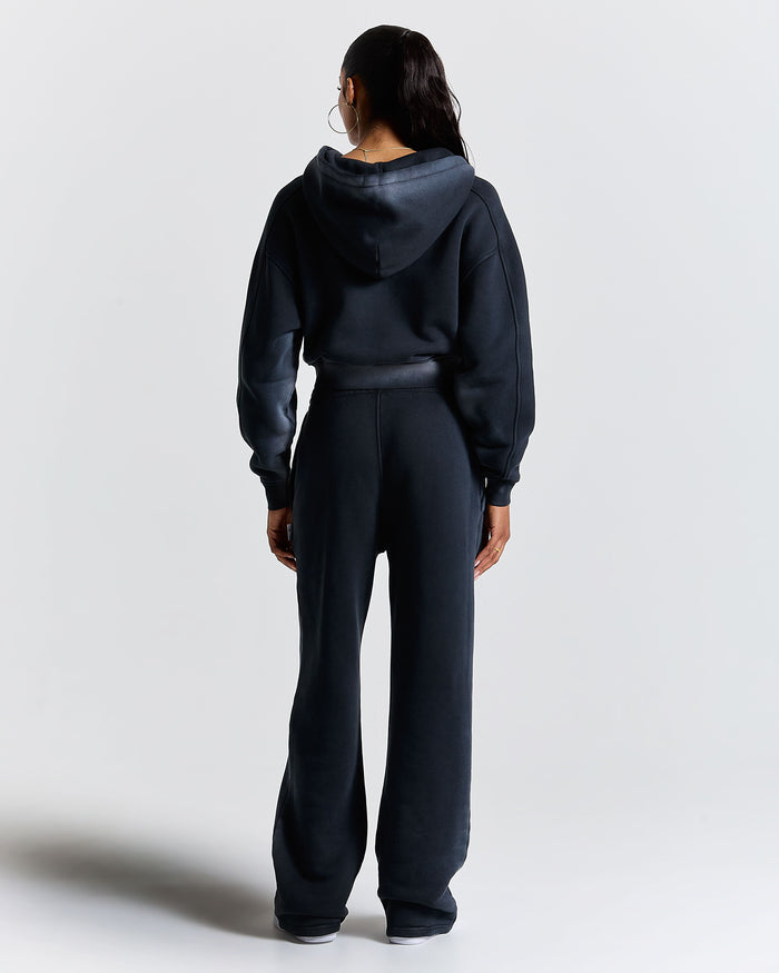 Person wearing a black tracksuit on a white background
