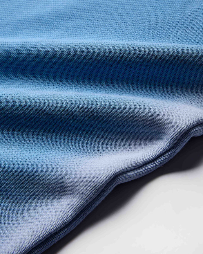 Close-up of blue fabric with a gradient effect on a white background