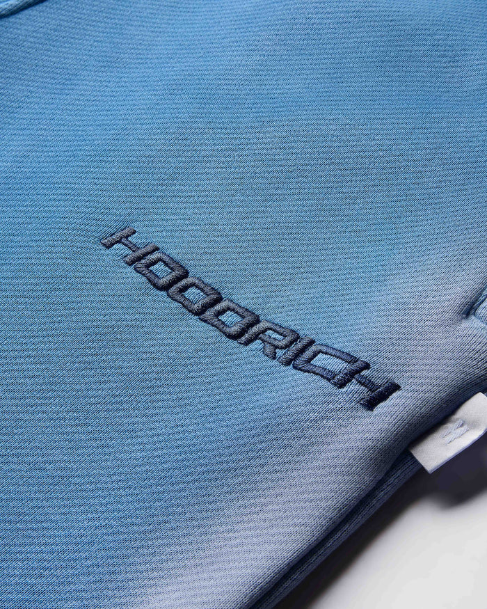 Close-up of a blue fabric surface with 'Hoodrich' branding.