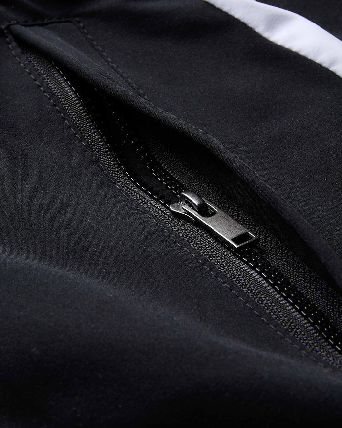 Close-up of a black jacket zipper with a white stripe in the background