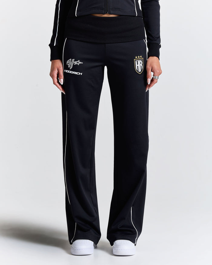 Displays a model wearing the Black 'Hoodrich' branded women's Glide Football Full Tracksuit