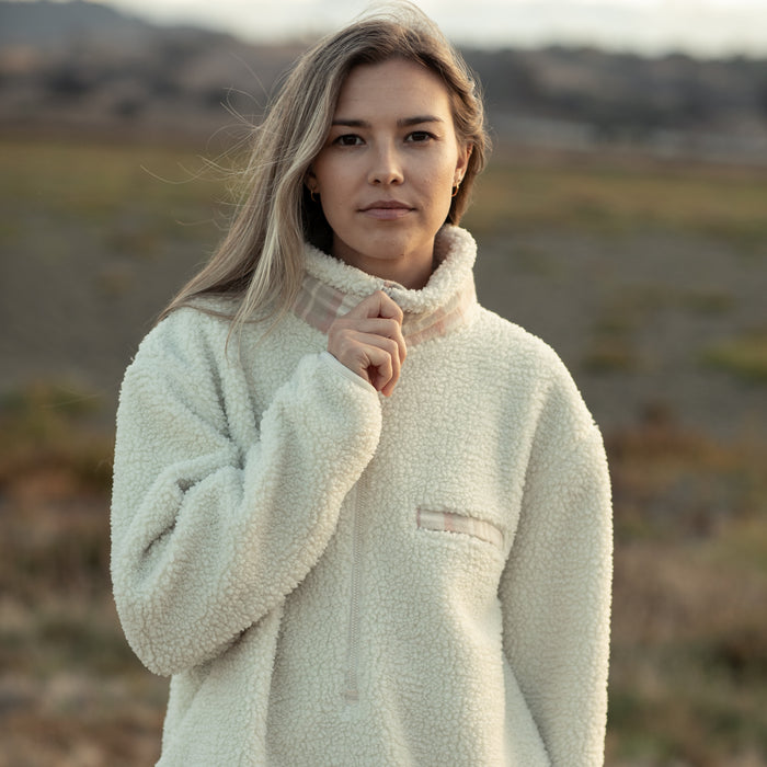 Woman in a Pladra Women's Jenner Sherpa Fleece - Oatmeal White, standing outdoors and looking at the camera.