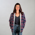 Women's Northwood Sherpa Insulated Flannel Jacket in Eagle Blue, worn over a dark grey V-neck with blue jeans.