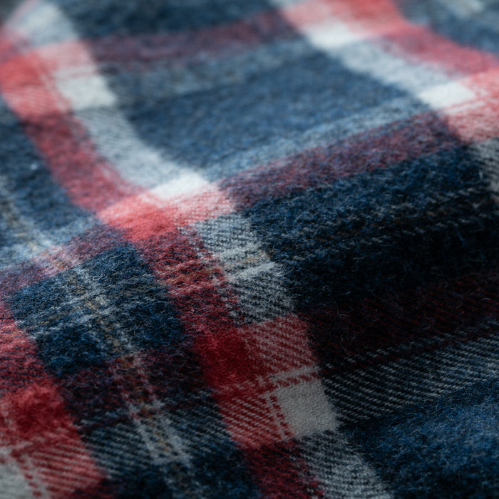 Close-up of the Women's Northwood Sherpa Insulated Flannel Jacket in Eagle Blue, showing its soft, fuzzy flannel fabric in a navy blue, red, and white plaid with clearly visible Sherpa insulation and textured fibers.