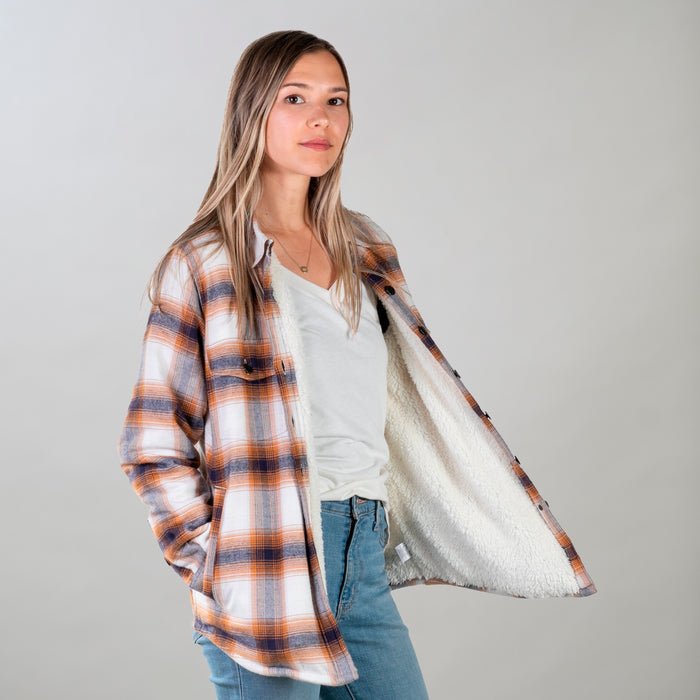 Woman in Pladra Women's Northwood Sherpa Insulated Flannel Jacket- Peak White, revealing its fuzzy lining.