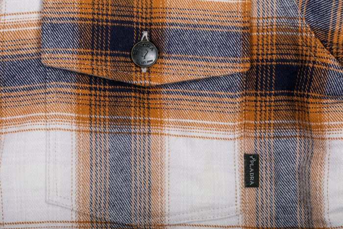 Close-up of Pladra Women's Northwood Sherpa Insulated Flannel Jacket- Peak White, showing pocket, button, and label.