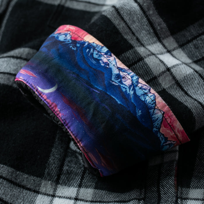 The Pladra Women's Northwood Sherpa Insulated Flannel Jacket in RP Onyx Black features a mountain and moon design.