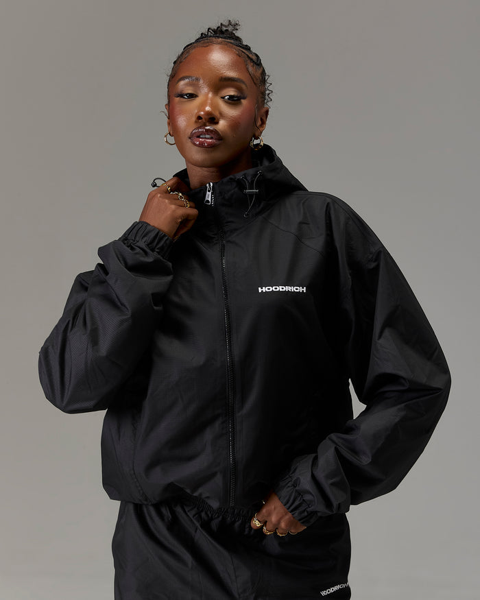 Displays a model wearing the Black 'Hoodrich' branded women's The Winner's Circle Ripstop Woven Full Tracksuit