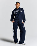 Person wearing a navy tracksuit with 'Hood Rich' branding on a light gray background