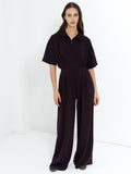 Woman wearing a brown half zip jumpsuit with short sleeves wide leg trousers an elasticated waist two side pockets and a relaxed fit.