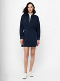 A woman wearing a half navy blue half zip mini dress with long sleeves, 2 side pockets and a collared neckline.