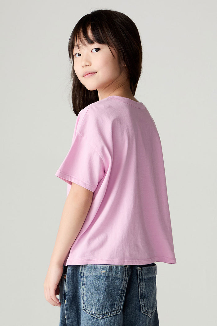Back view of a girl wearing the Chaser Yee Haw Girls Tee and jeans on a neutral background looking over one shoulder