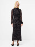 A woman wearing a  black maxi dress with an abstract print, semi sheer long sleeves and a mock neckline.