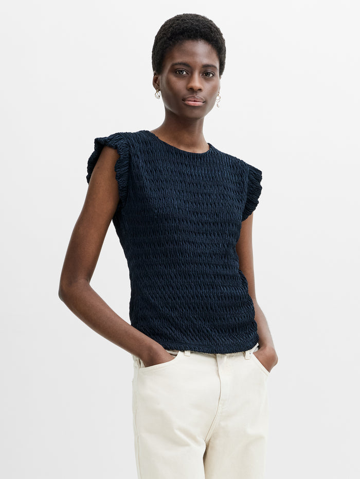 A woman wearing a Navy Blue Textured Top features a crew neck, frilled cap sleeves and back button fastening.